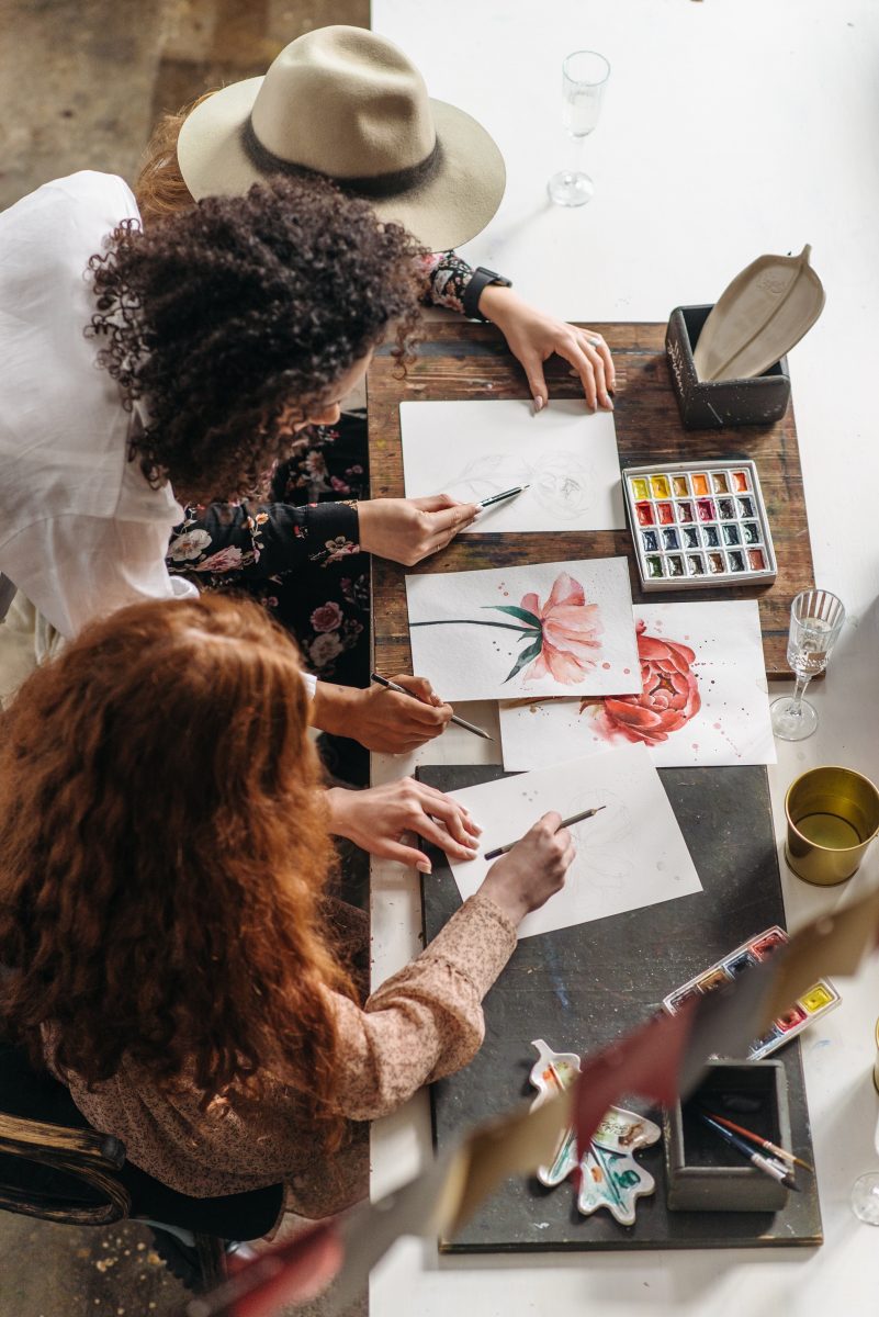 three women making flower art