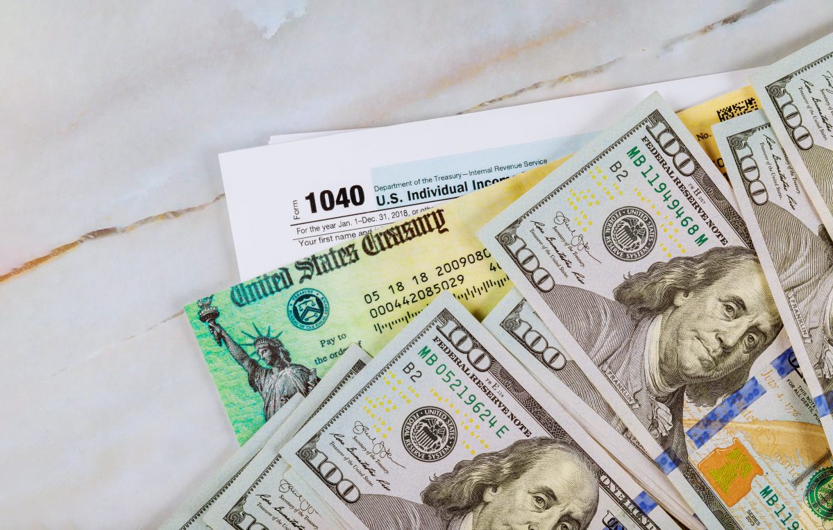 Tax return documents and US 100 dollar bills 