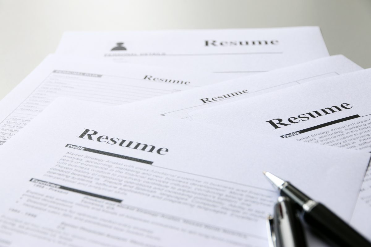 Perspective view of a stack of resumes on a table, focusing on the resume objective.