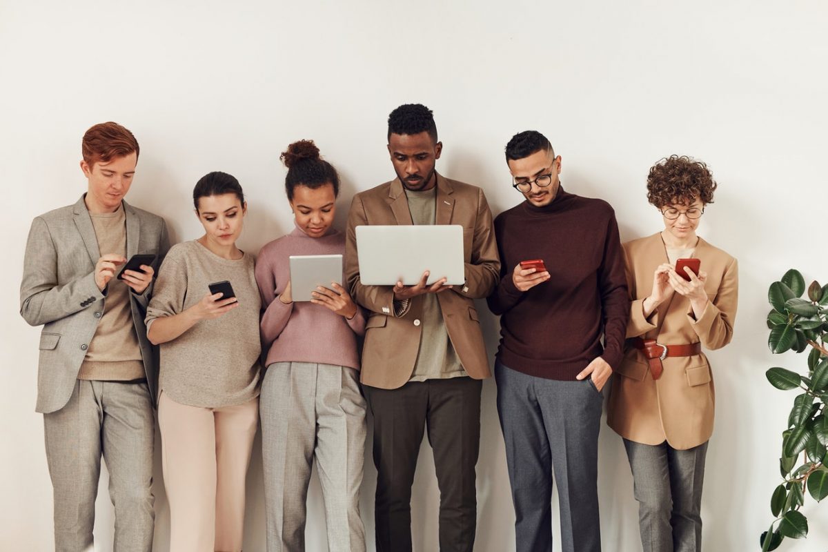  A group of people looking at their laptop and mobile phones.