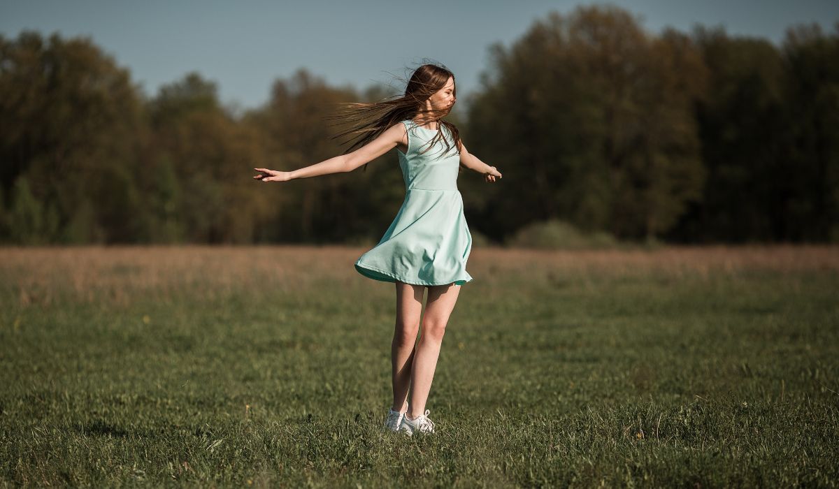 young woman in light green dress spinning around outdoors, how to dispose mirror without bad luck 