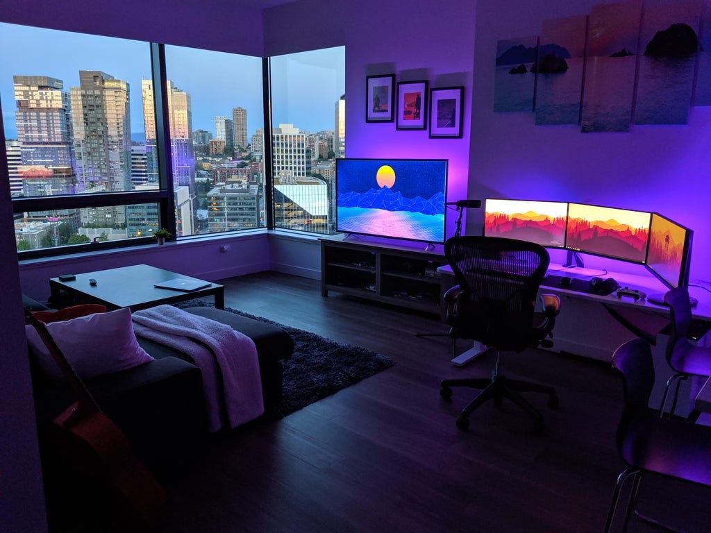 Living room gaming station with panoramic windows and a view of the city.