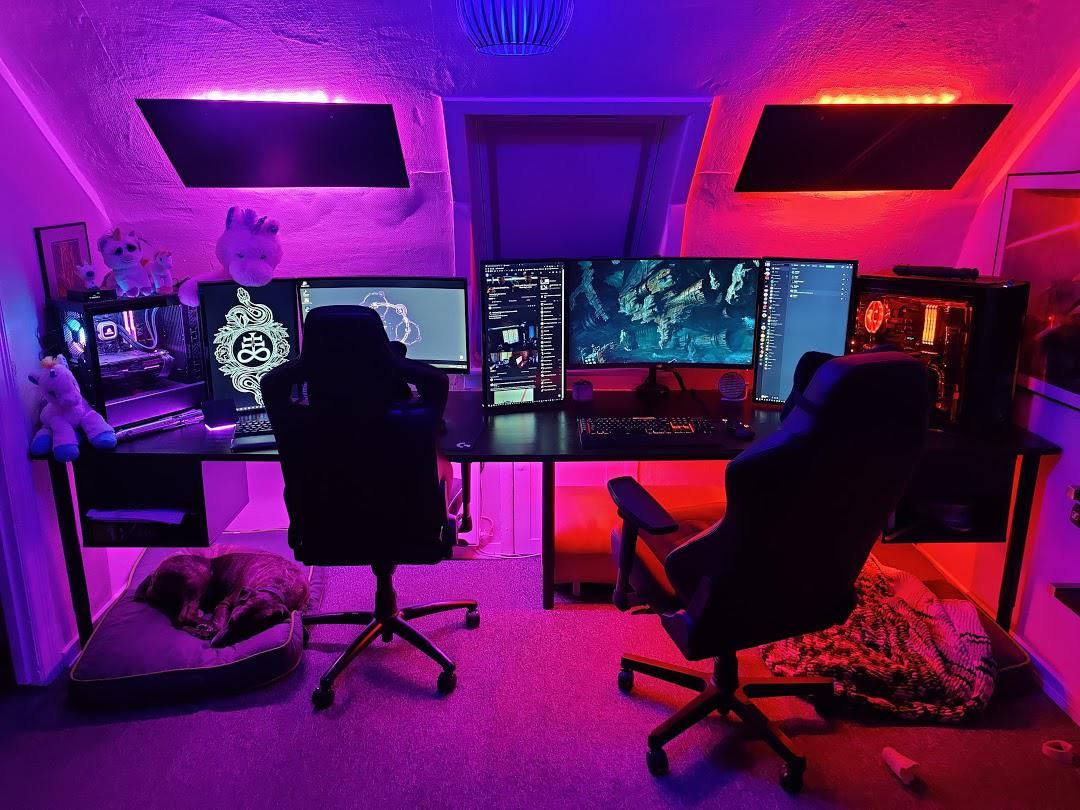 An attic double gaming station with multiple monitors.
