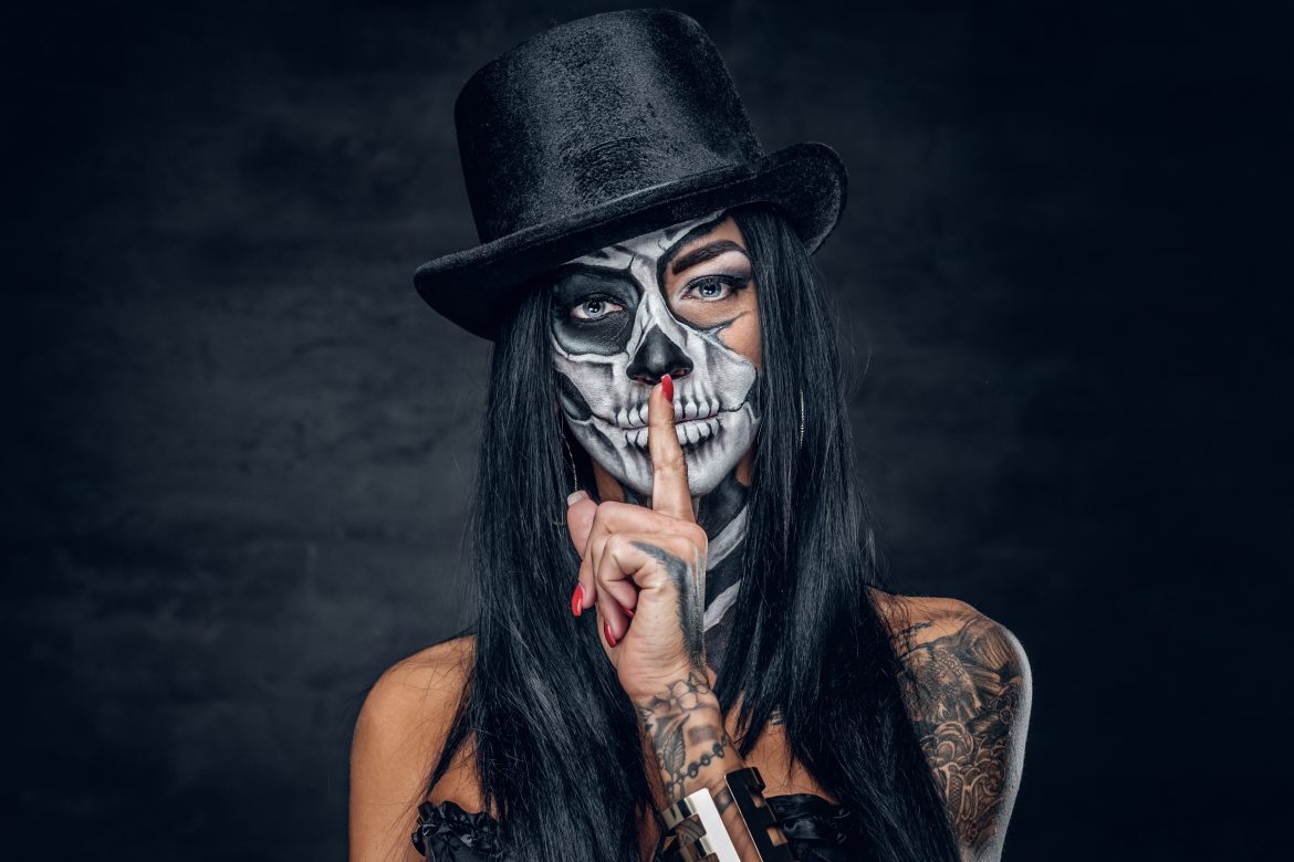 Female in Halloween silence. A woman in top hat and skull make up; halloween tattoo ideas.
