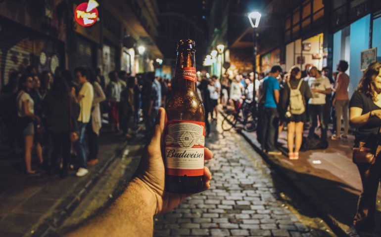 Photo of a hand holding up a beer.