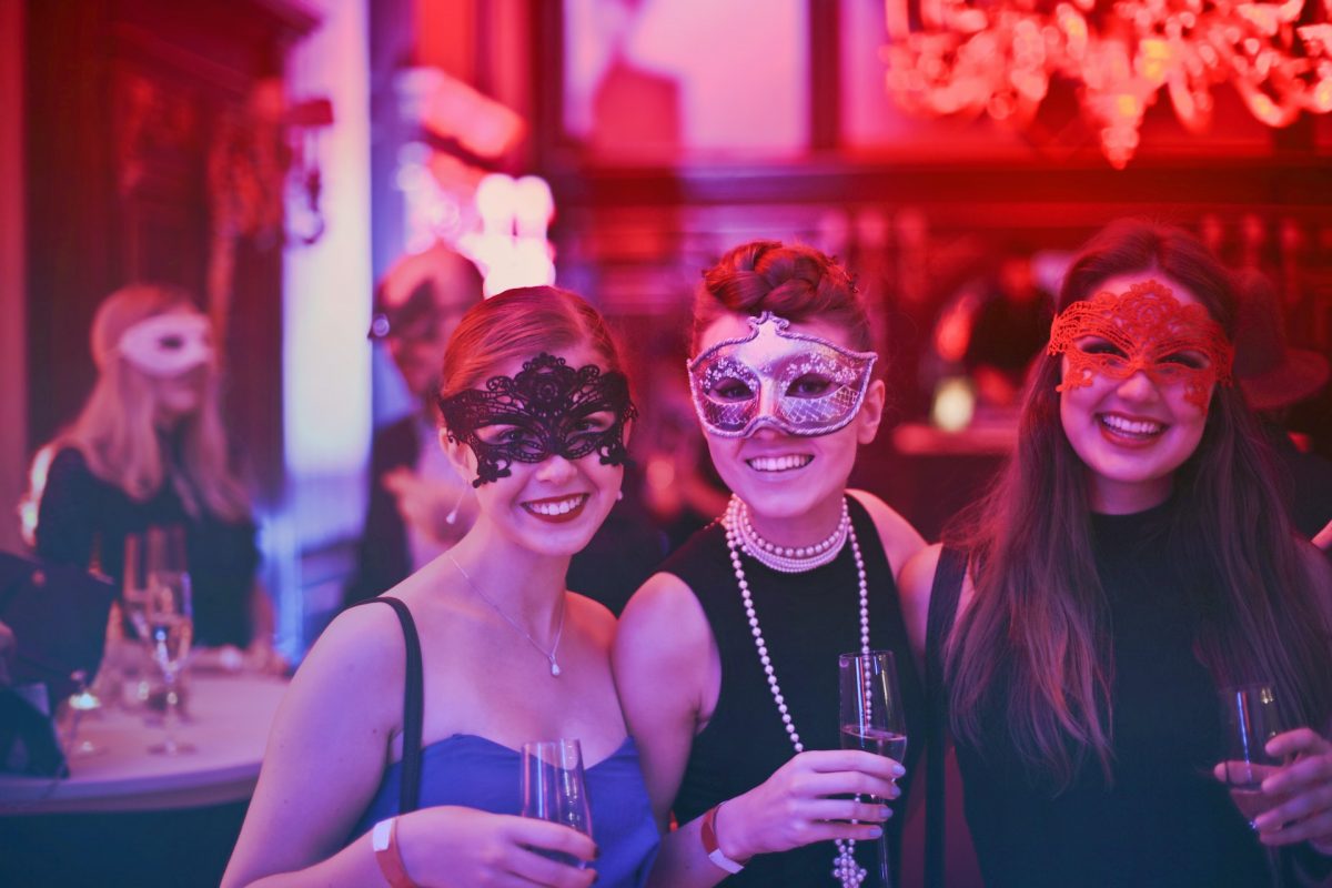Bar goers wearing masquerade masks.