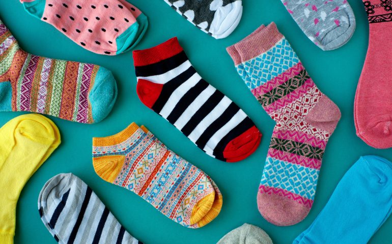 Many socks are scattered on a turquoise background