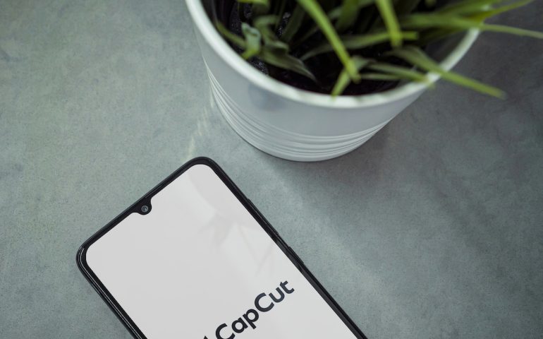 Modern workspace with smartphone with CapCut app launch screen on marble background