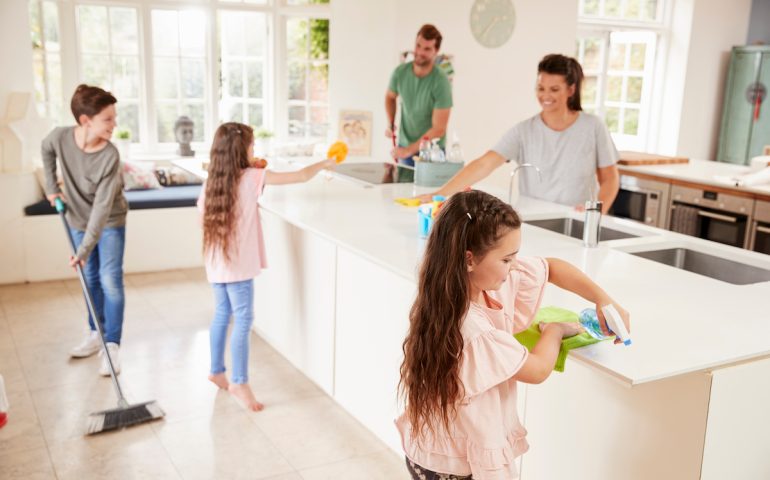 Children Helping Parents With Household Chores In Kitchen