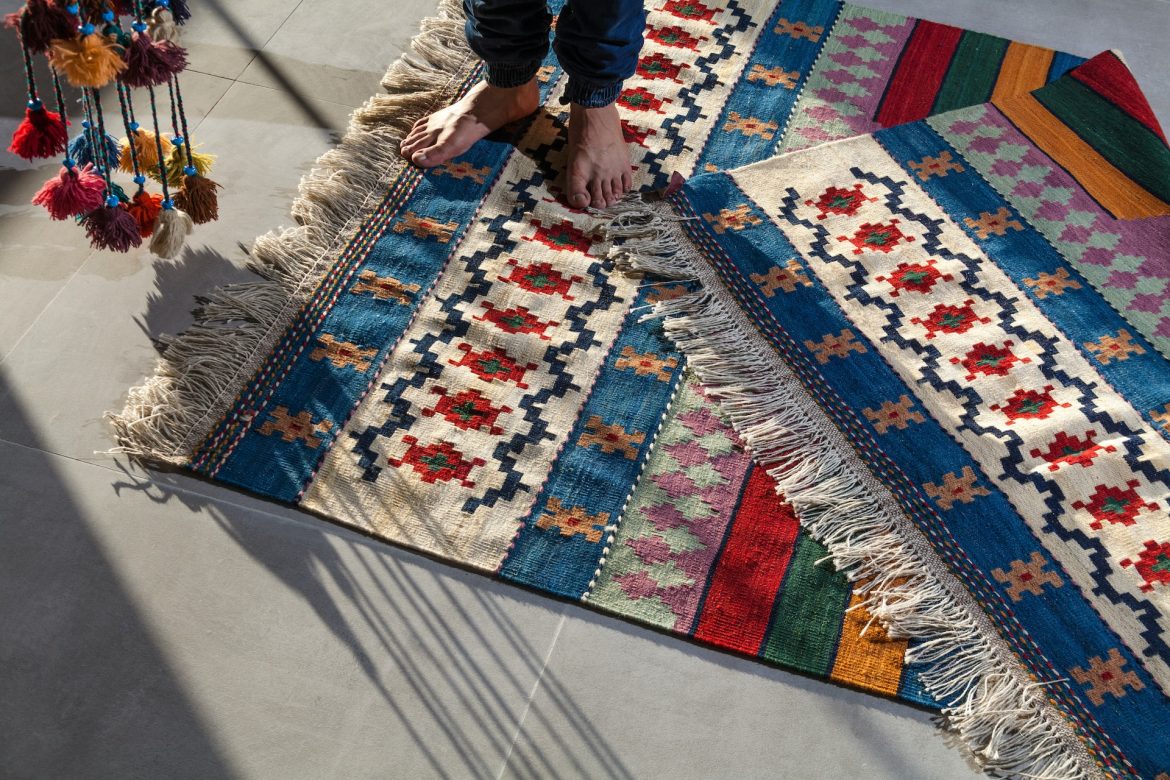 man standing on colorful rugs