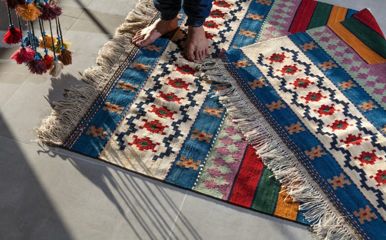 man standing on colorful rugs
